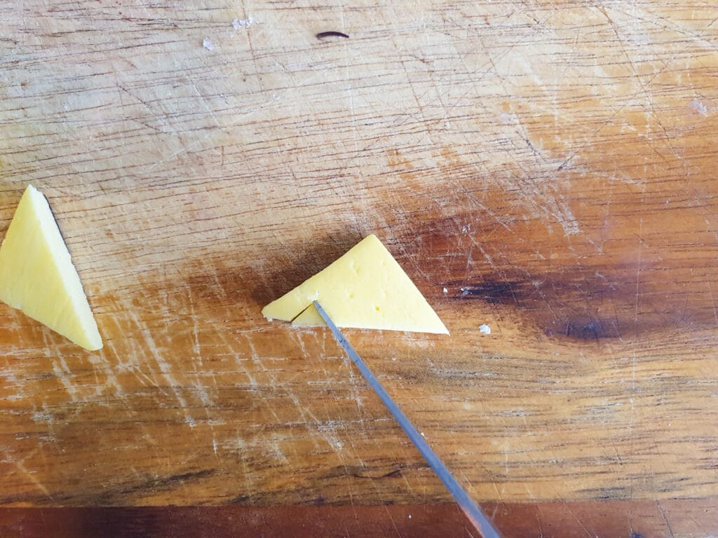 Cutting teeth into jack-o-lantern mouth decoration.