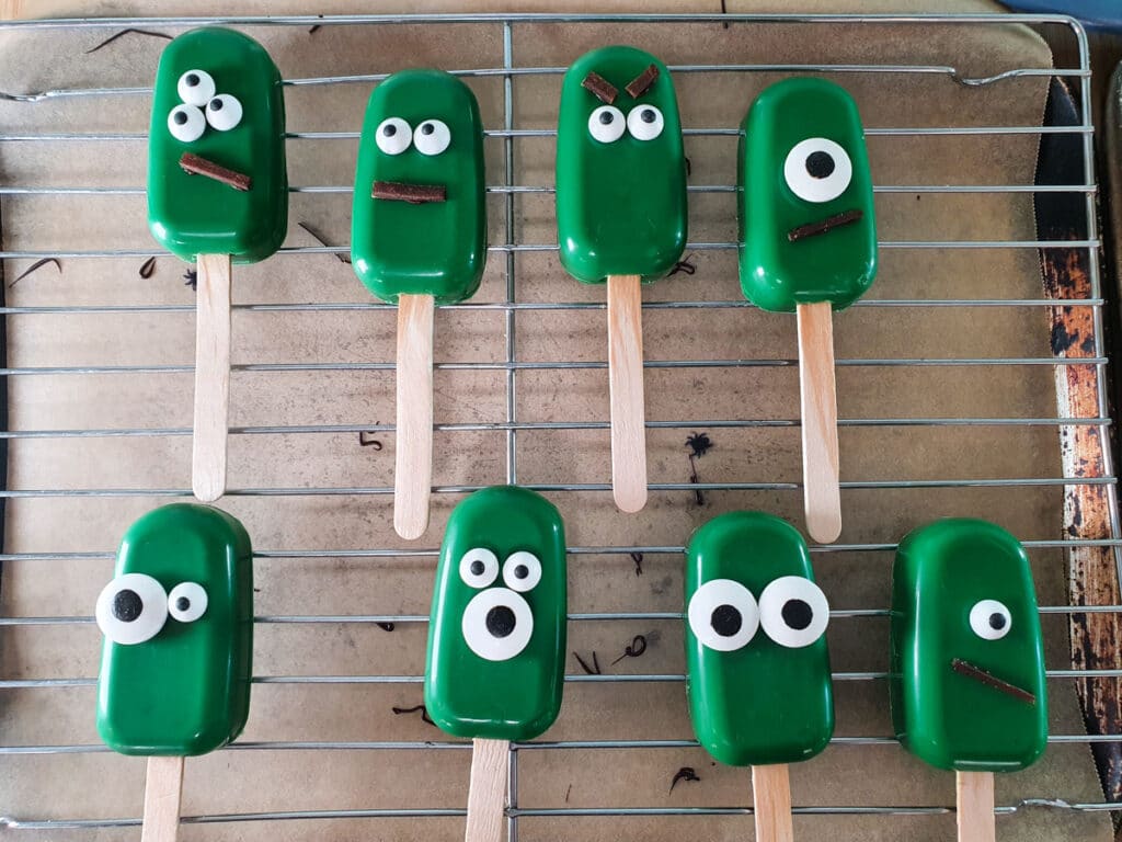 Sticking decorations onto monster cakesicles.