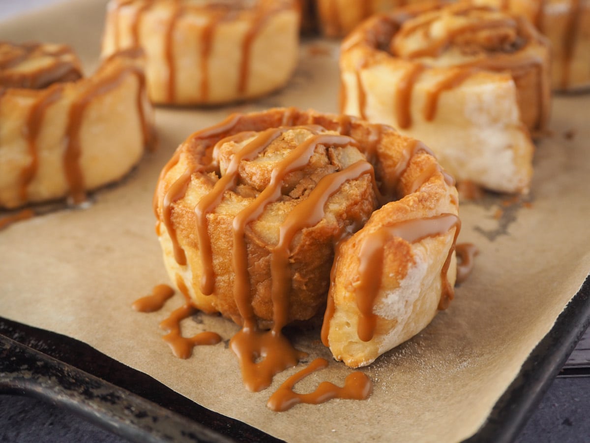 Biscoff roll drizzled with Biscoff on a baking tray.