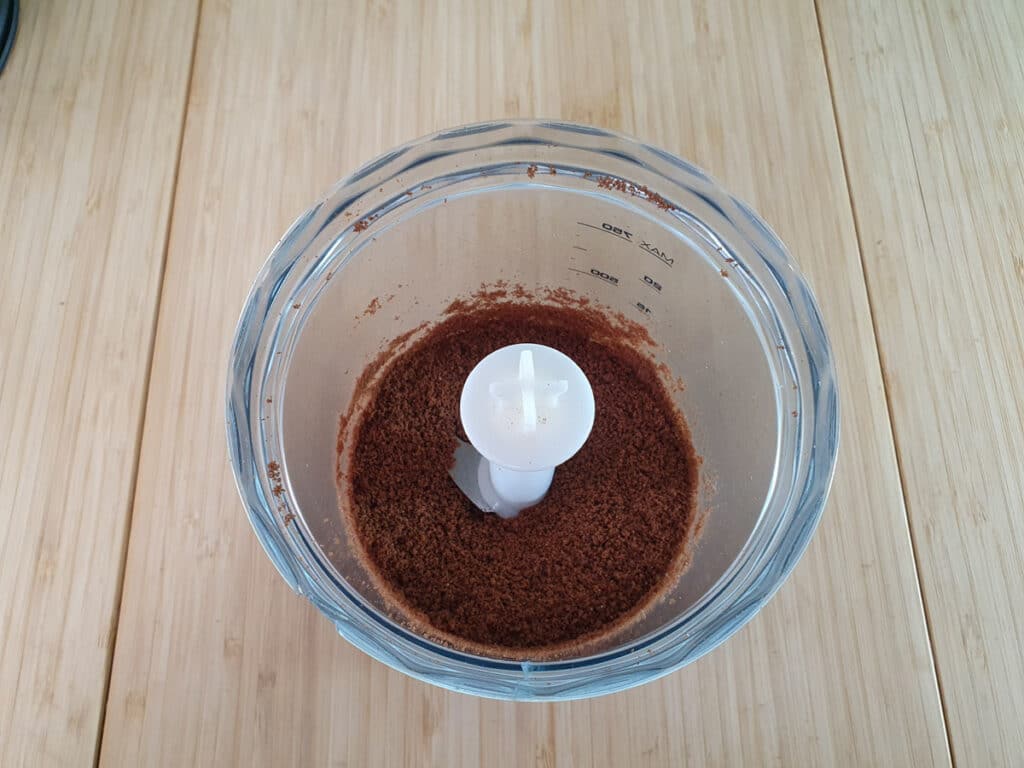 Blitzing the chocolate flavored cookies in a food processor.