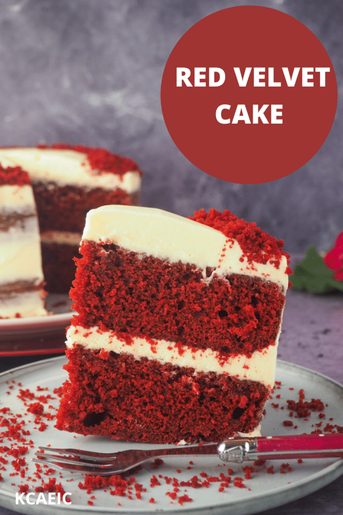 Chocolate red velvet cake on a plate with fork and cake and flowers in the background, with text overlay, Red Velvet Cake and KCAEIC.