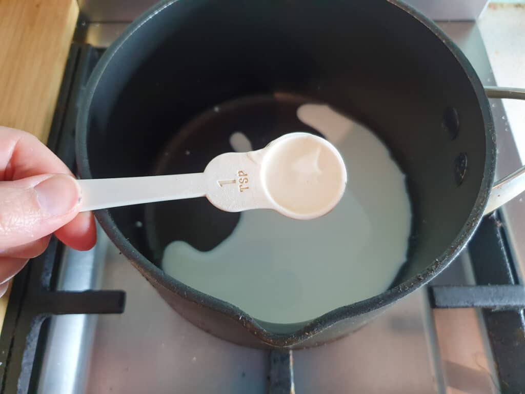 Adding glucose syrup to dash of milk.
