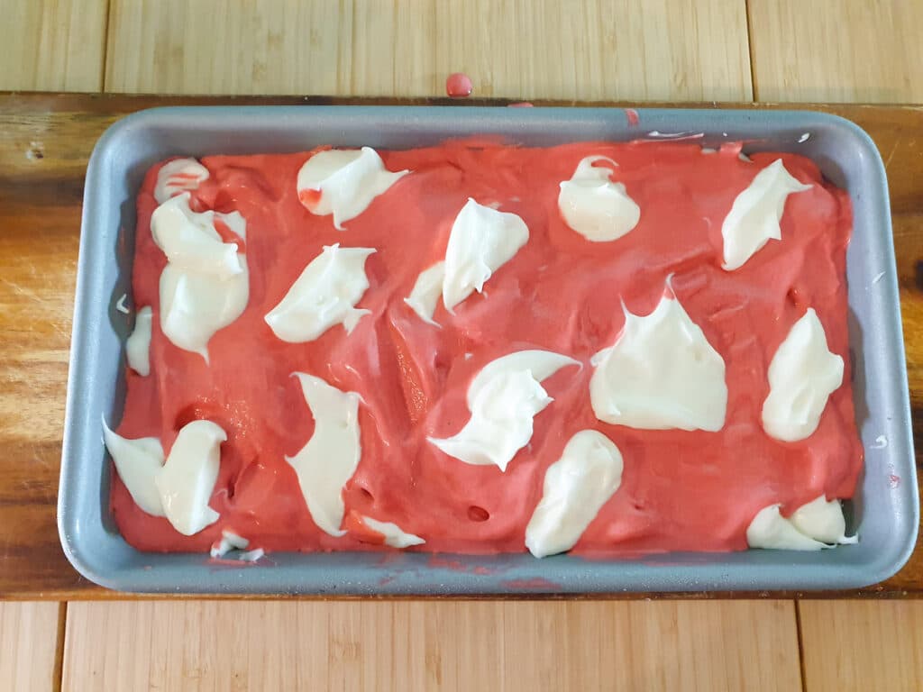 Final layer of red velvet ice cream and cream cheese frosting swirl.