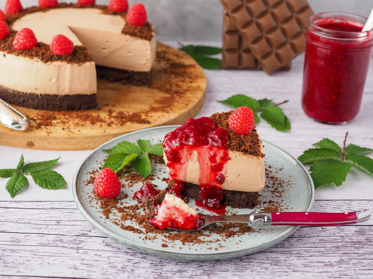 No Bake Chocolate Cheesecake 7 Slice of cheesecake with fresh raspberries and raspberry compote.