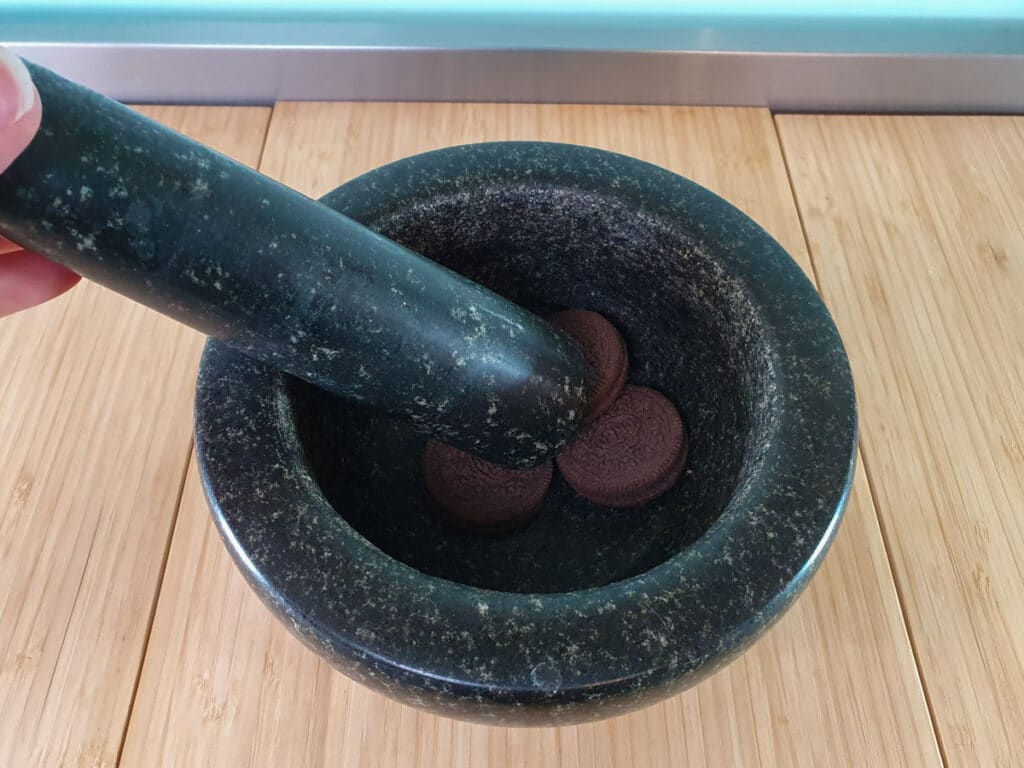 Oreo Mug Cake 4 Crushing up Oreos with motar and pestle.