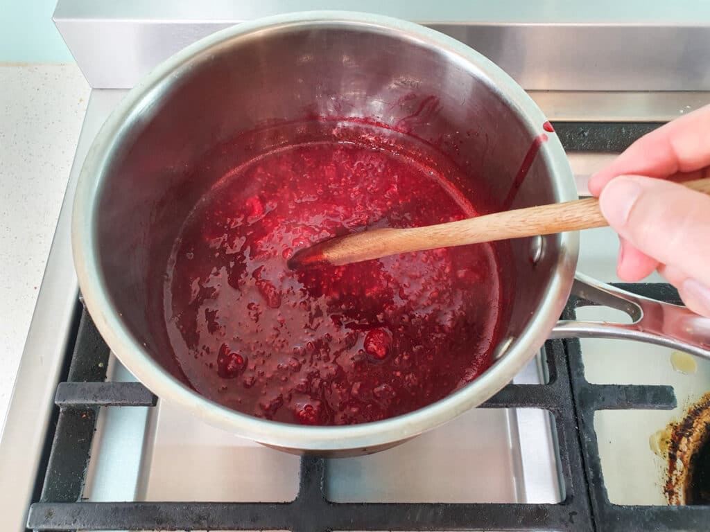 Gently stirring the compote.