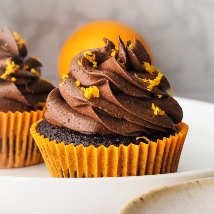 Close up cupcake with fresh orange in background.