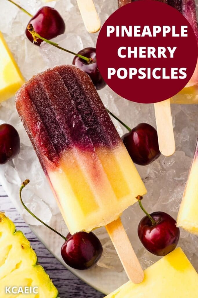 Popsicles on a bed of ice with fresh cherries and pineapple, with text overlay, pineapple cherry popsicles and KCAEIC.