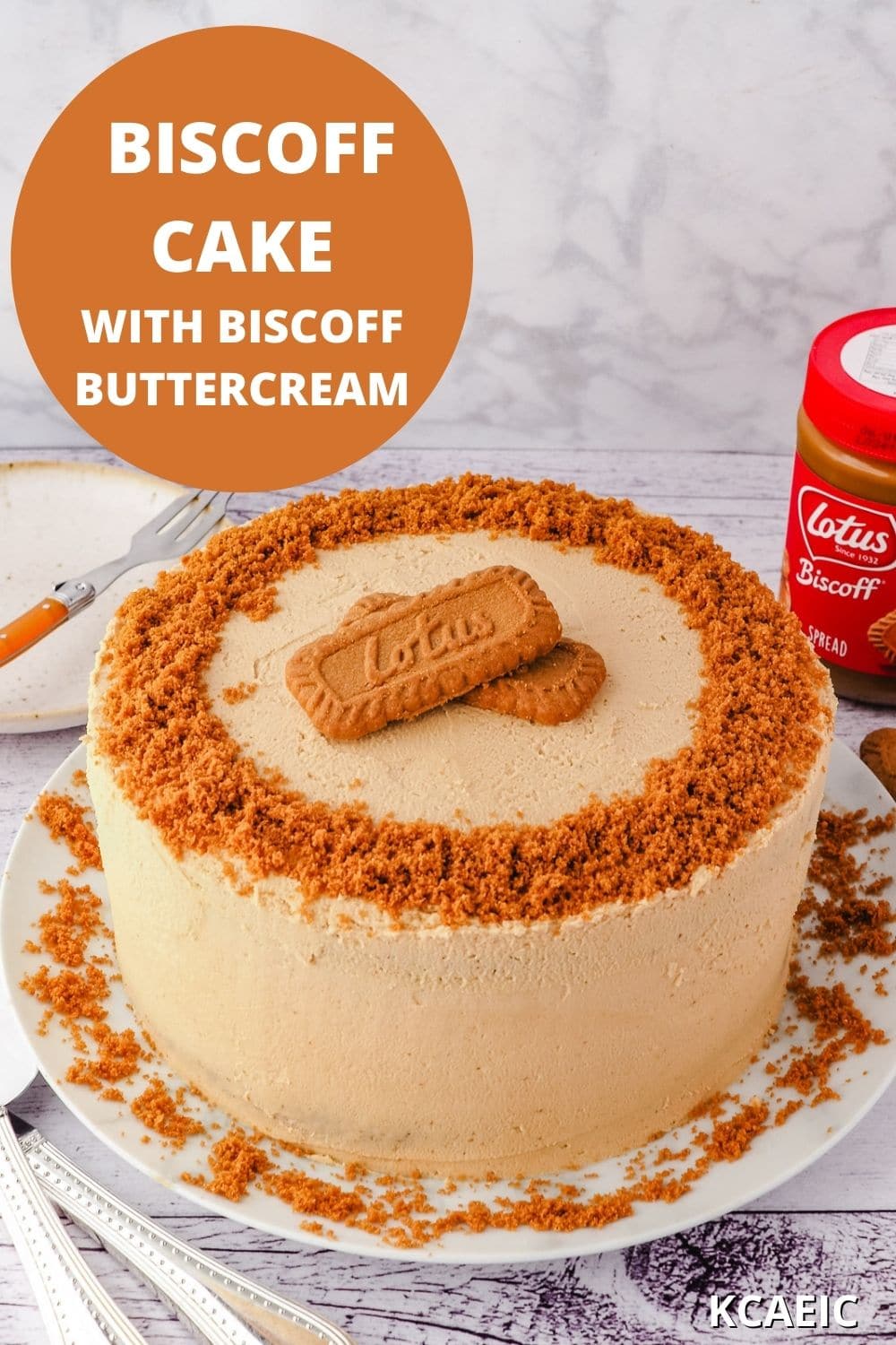 Whole cake on a plate, with serving ware, jar of biscoff spread and serving plate and fork on the side, with text overlay.
