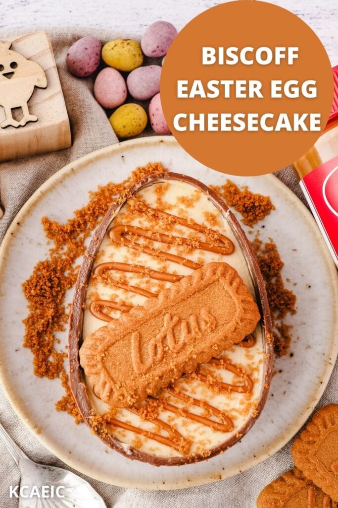 Cheesecake on a plate drizzled with spread, whole biscuit and crumbs, with text overlay.