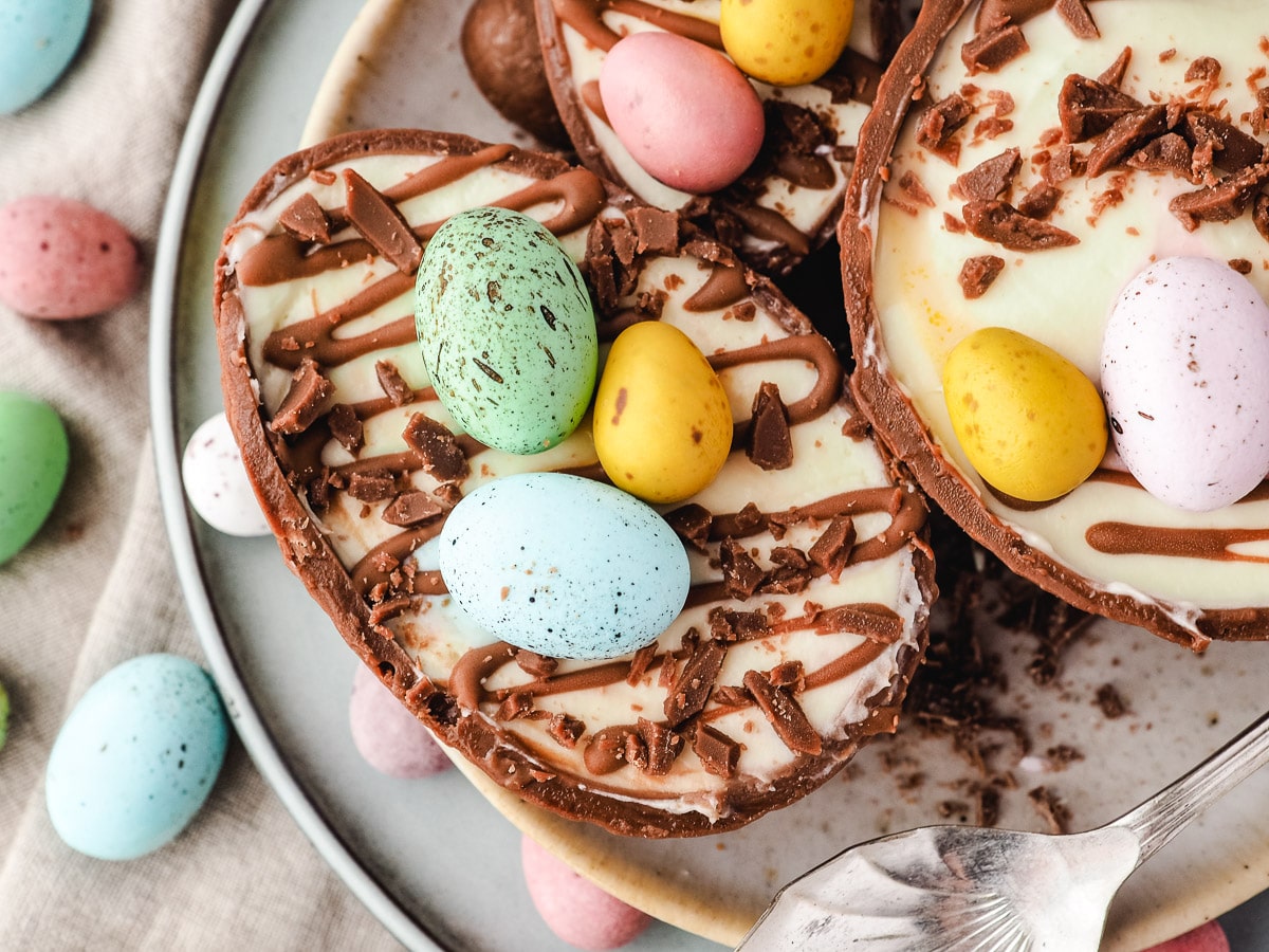 Large, medium and small Easter egg cheesecakes on a plate.