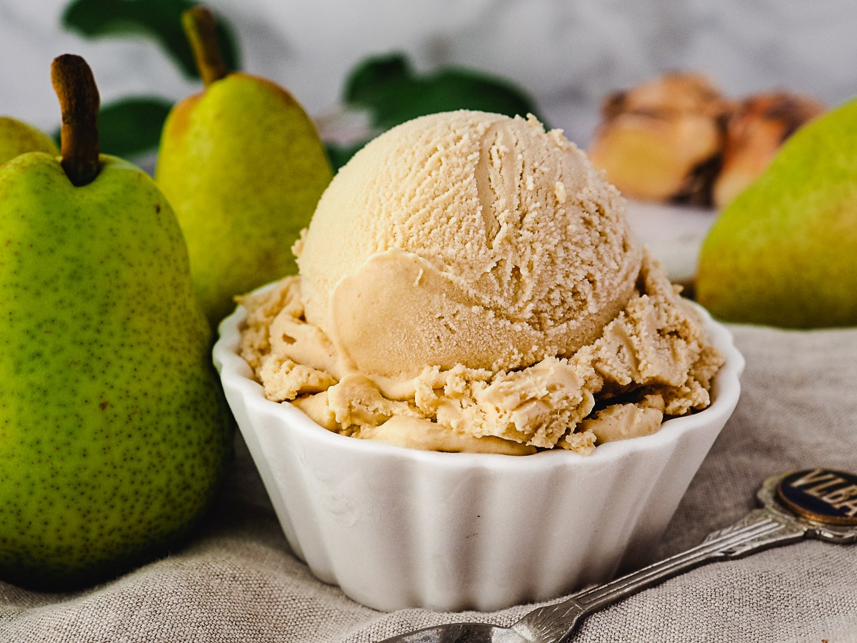 Pear ice cream 8 Scoop of pear ice cream with spoon, fresh pears and fresh ginger on the side.