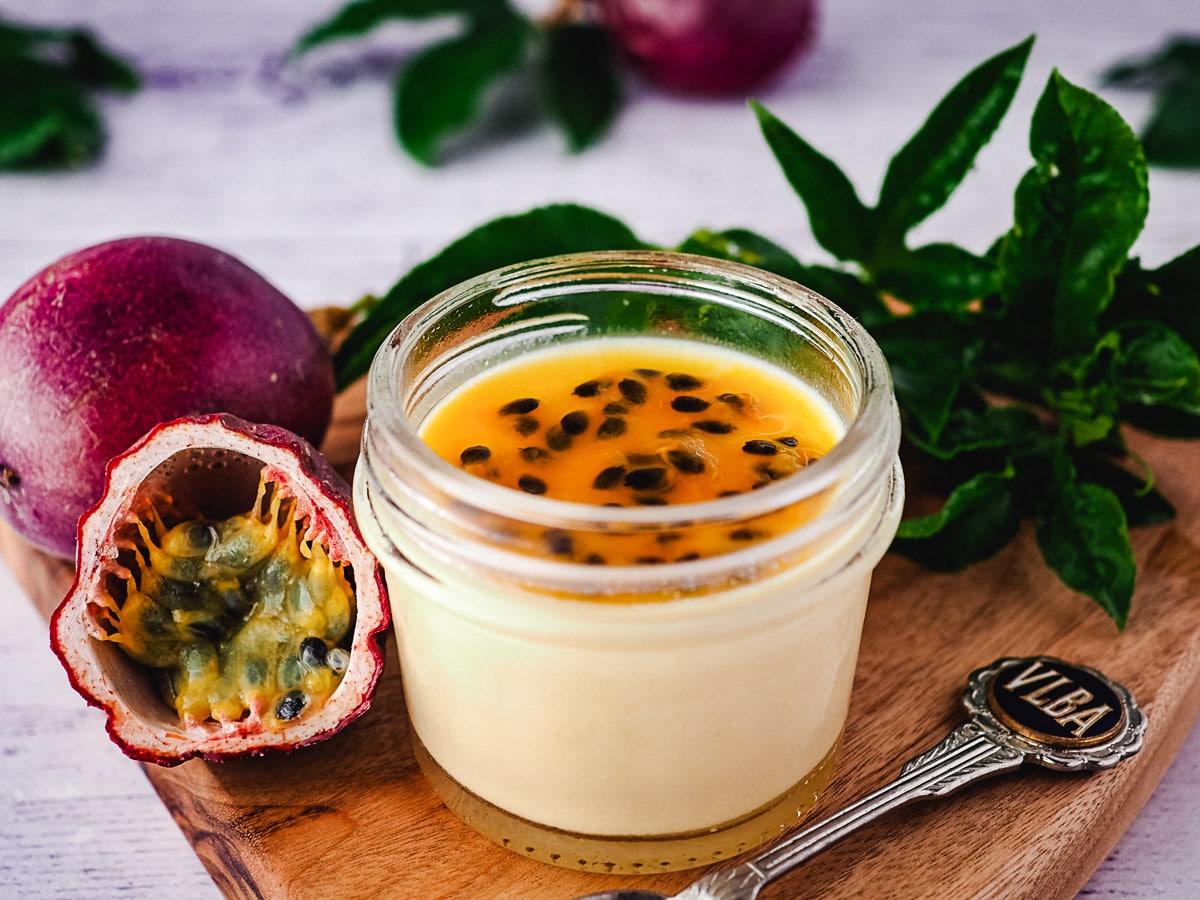 Small mason jar of panna cotta with passion fruit coulis.