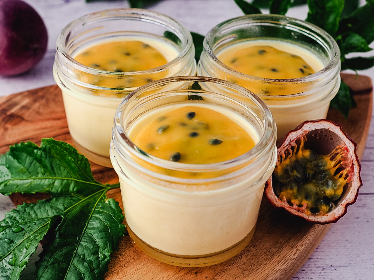 3 small mason jars of panna cotta with passionfruit curd.