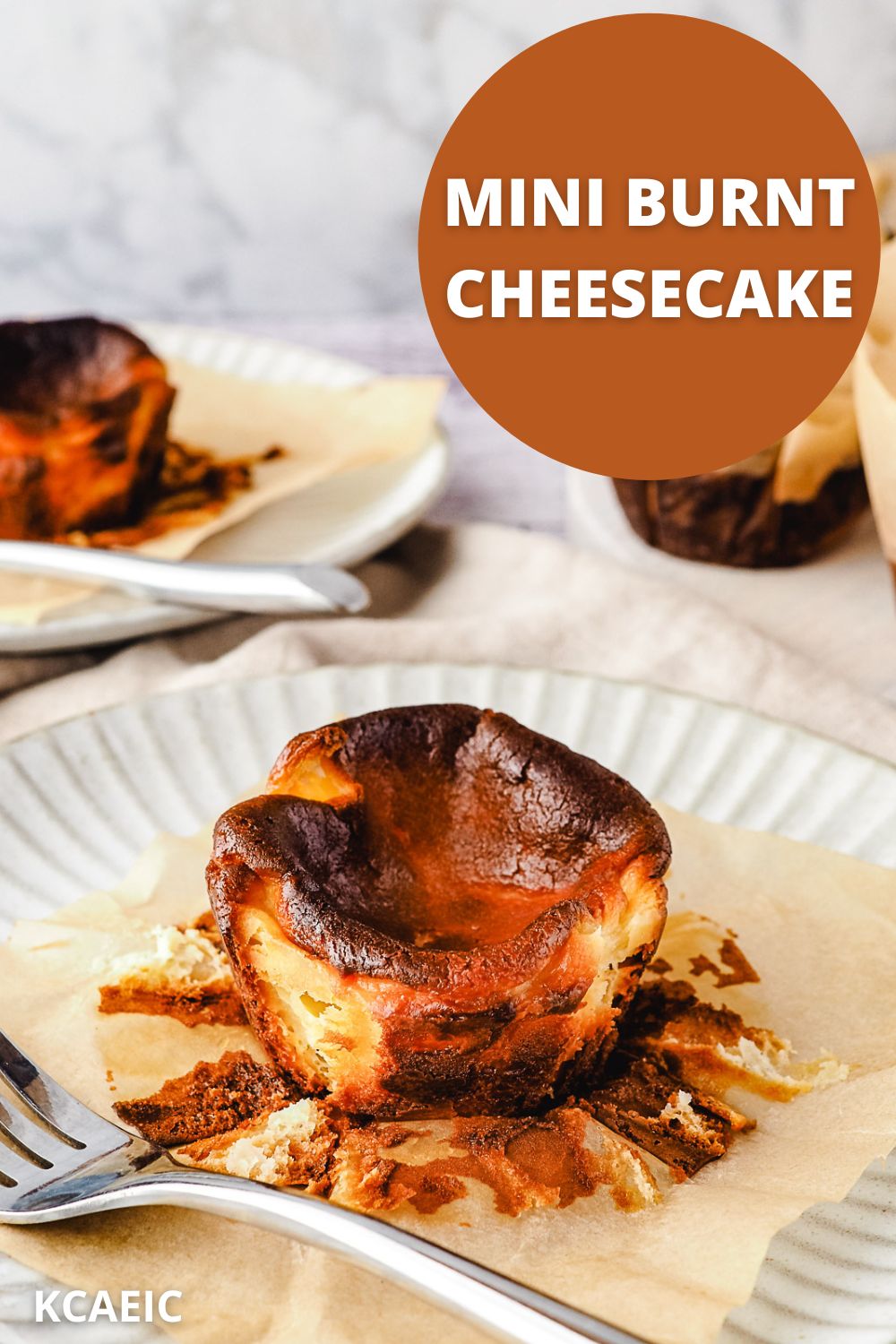 Mini Burnt Cheesecake 11 Mini cheesecake on a plate with a fork, rest of cheesecakes in back ground and text overlay.