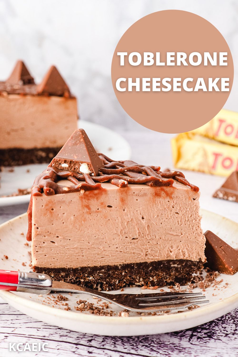 Slice of Toblerone cheesecake on a plate, with rest of cheesecake and more Toblerone in background, with text overlay.