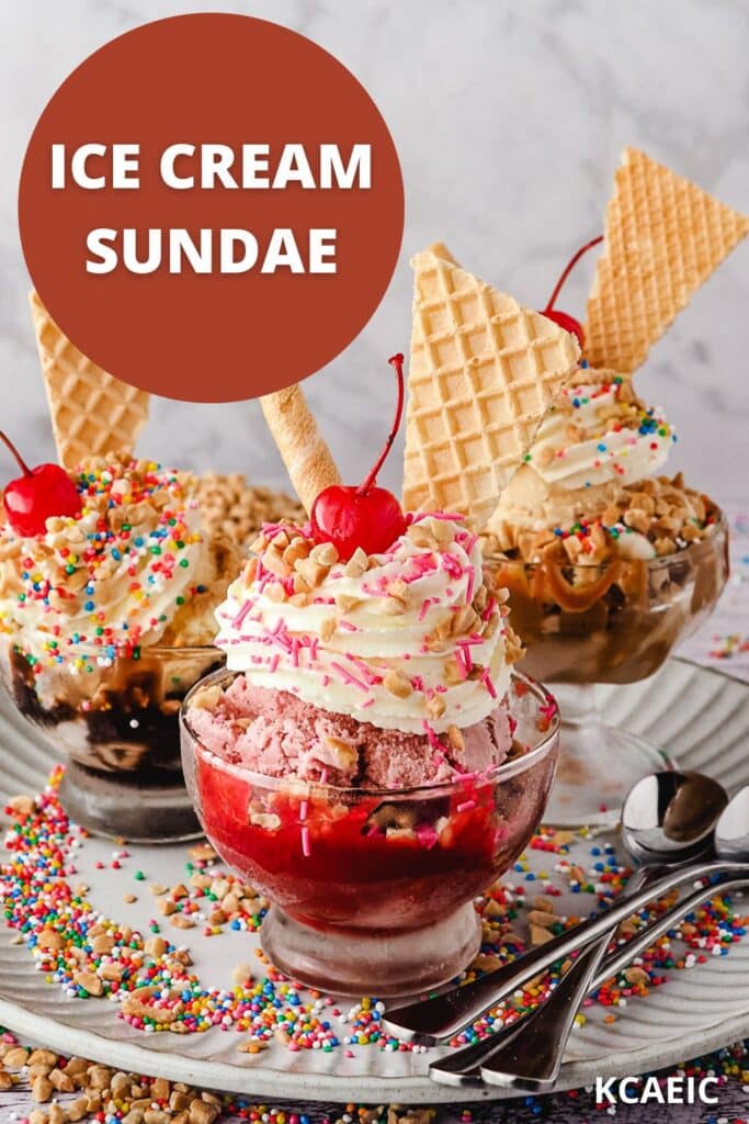 Group of three sundaes, strawberry, classic and caramel, with whipped cream, nuts, sprinkles, wafers and cherry, on a plate with spoons, nuts and sprinkles.