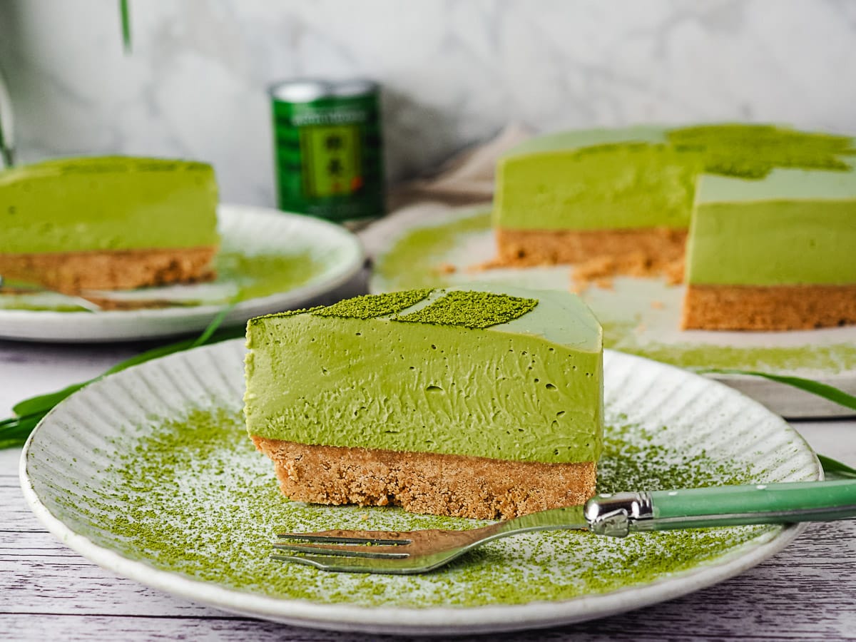 Slice of cake on a plate with a fork and rest of cake in background.