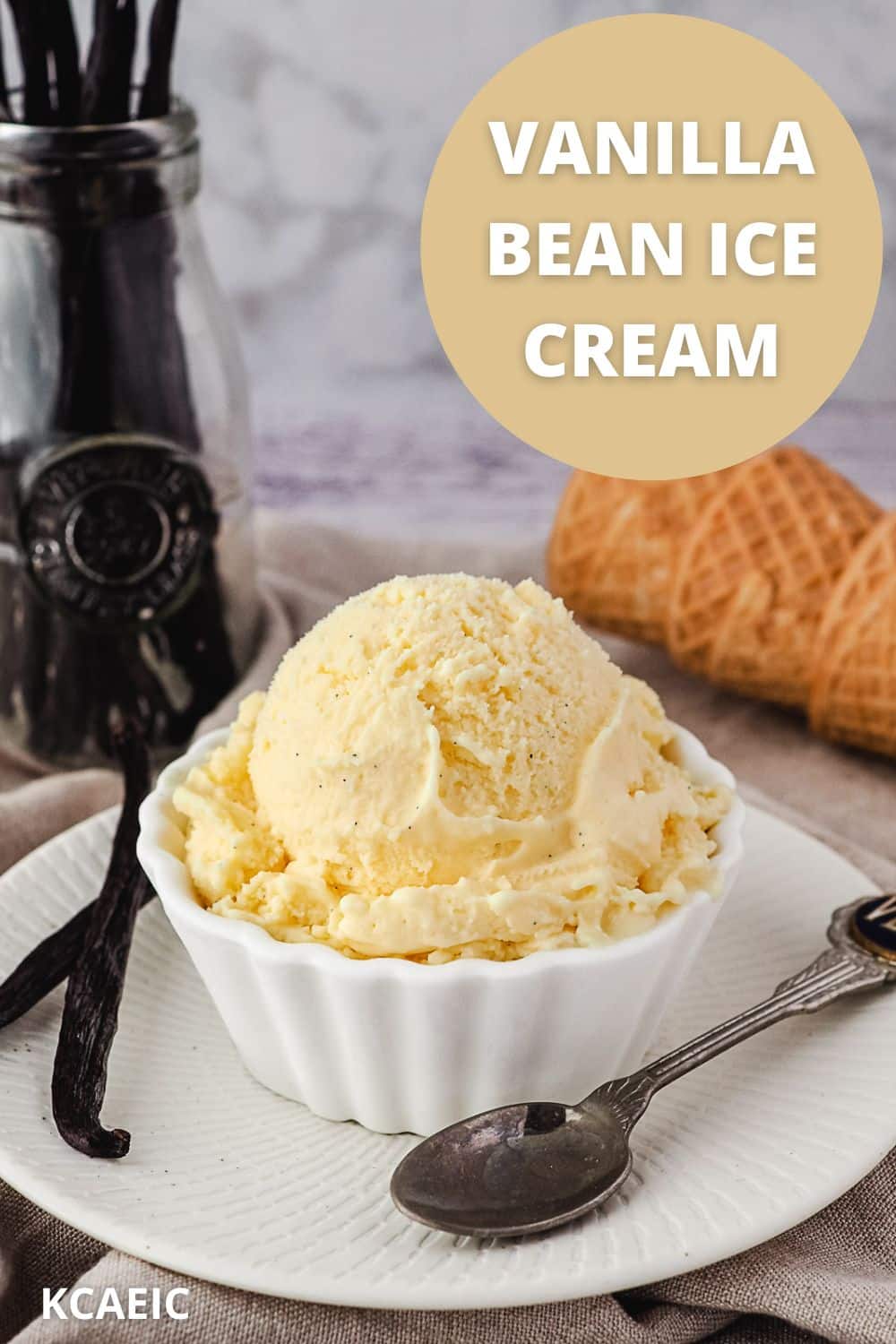 Scoop of ice cream in a bowl, with vanilla beans and spoon on the side and ice cream cones in background, with text overlay.