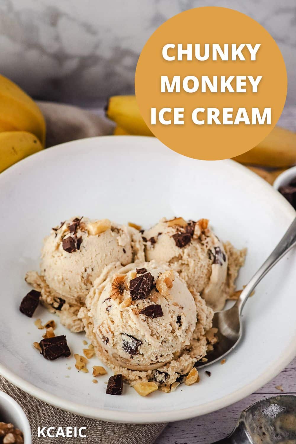Three scoops of ice cream in a bowl garnished with walnuts and chocolate chunks with a spoon on the side, and text overlay chunky monkey ice cream.
