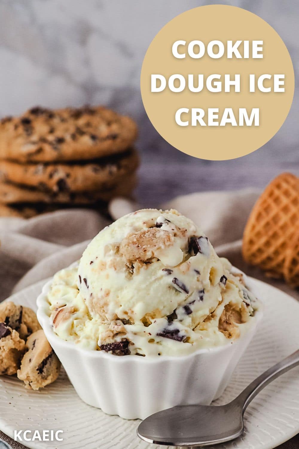 Scoop of ice cream in a bowl with a spoon and pieces of edible cookie dough on the side, with cookies and ice cream cones in the background, and text overlay.