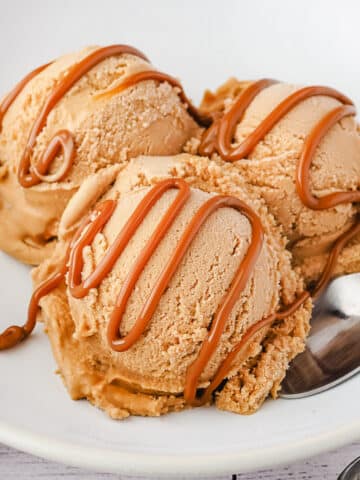 Close up three scoops dulce de leche ice cream with drizzle.