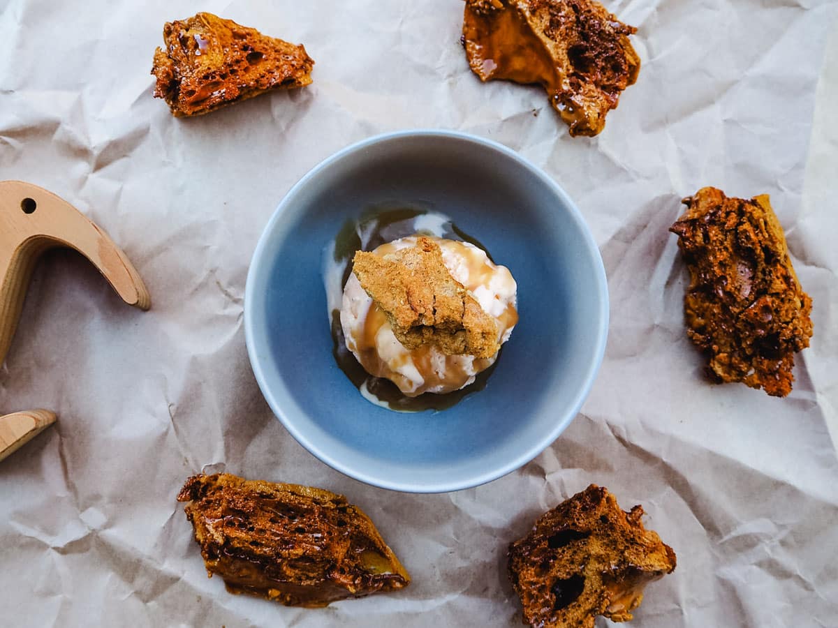 Scoop of hokey pokey ice cream with caramel sauce and fresh honeycomb.