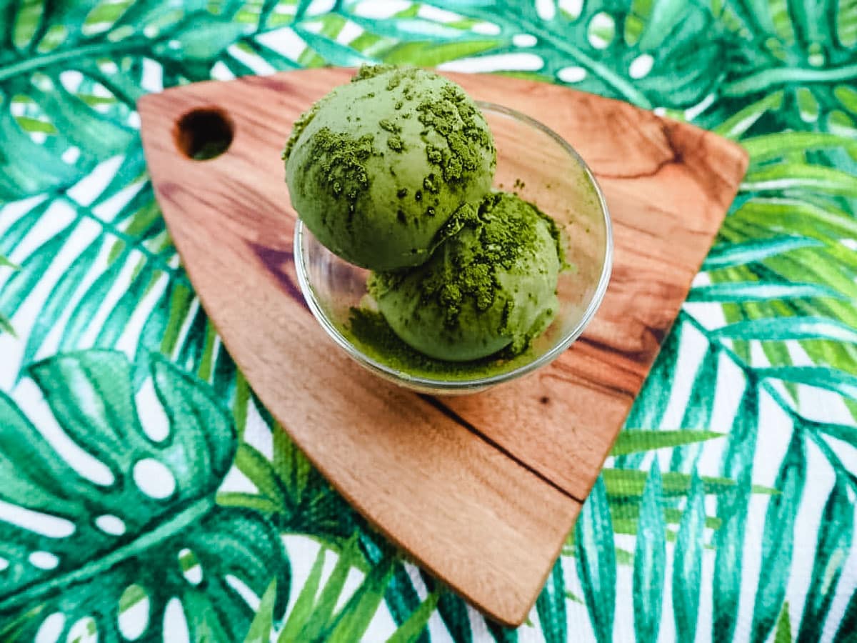 2 scoops of matcha ice cream sprinkled with matcha powder.