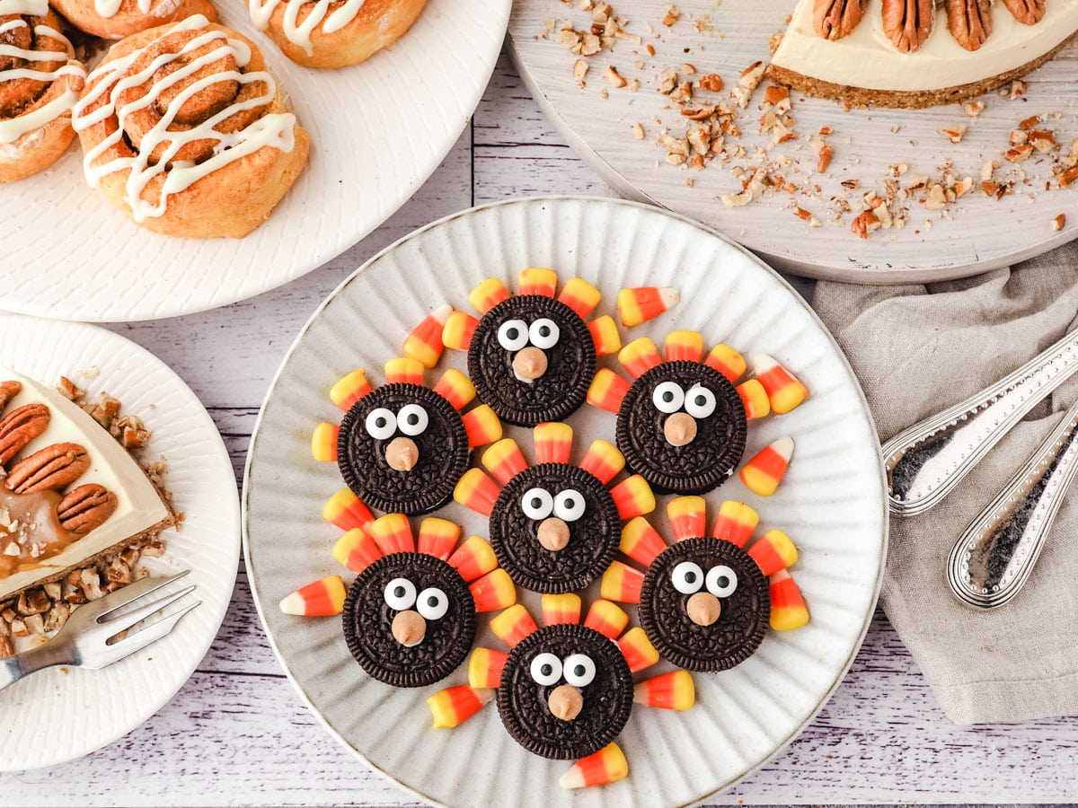 Oreo turkey cookies with thanks giving desserts, cinnamon scrolls and caramel pecan cheesecake.