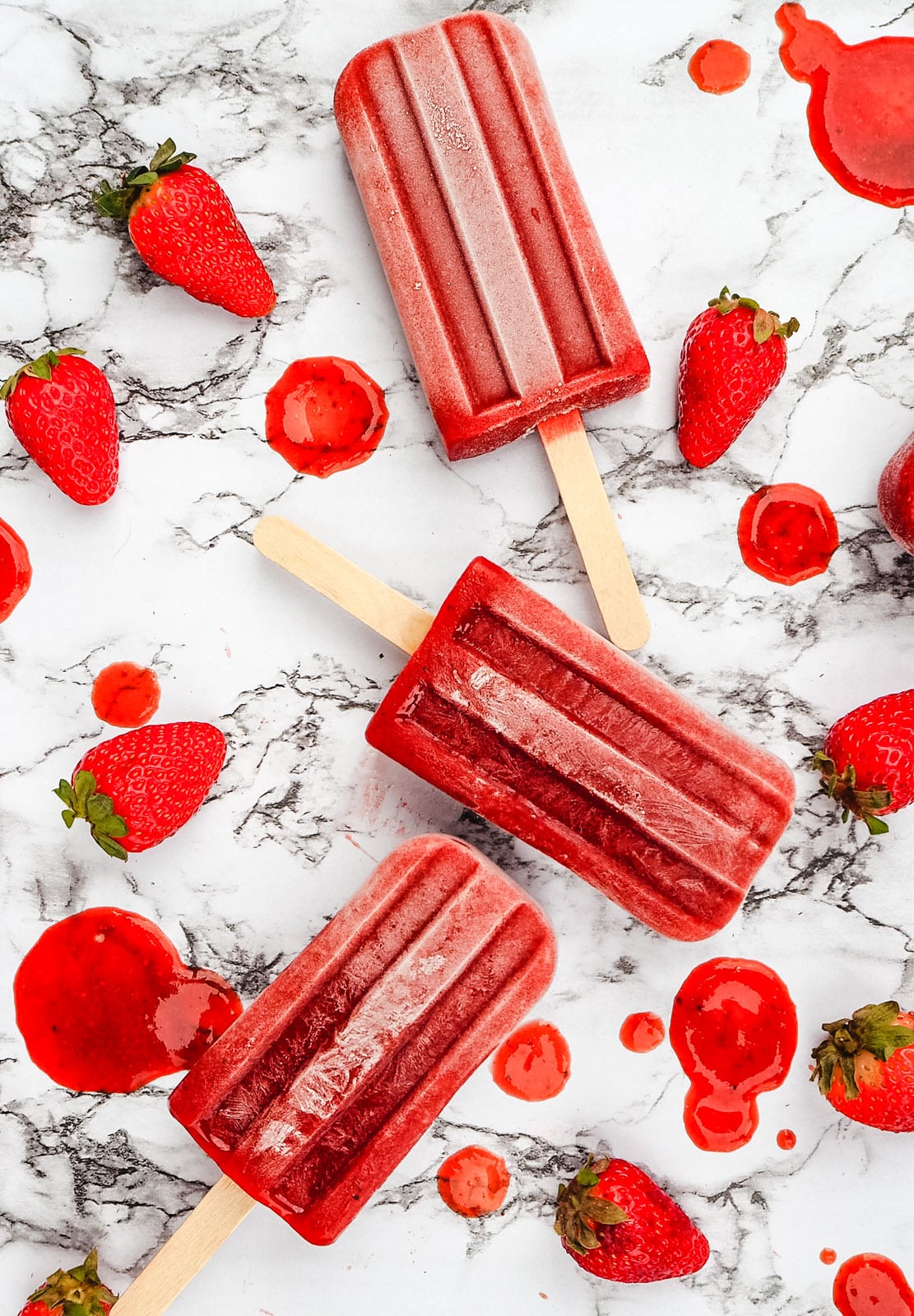 Strawberry balsamic popsicles with fresh strawberries.
