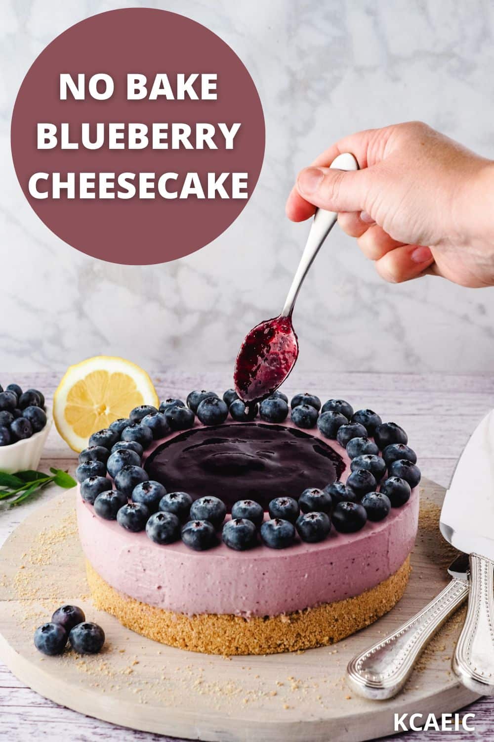 Blueberry coulis being spooned onto a no bake blueberry cheesecake.