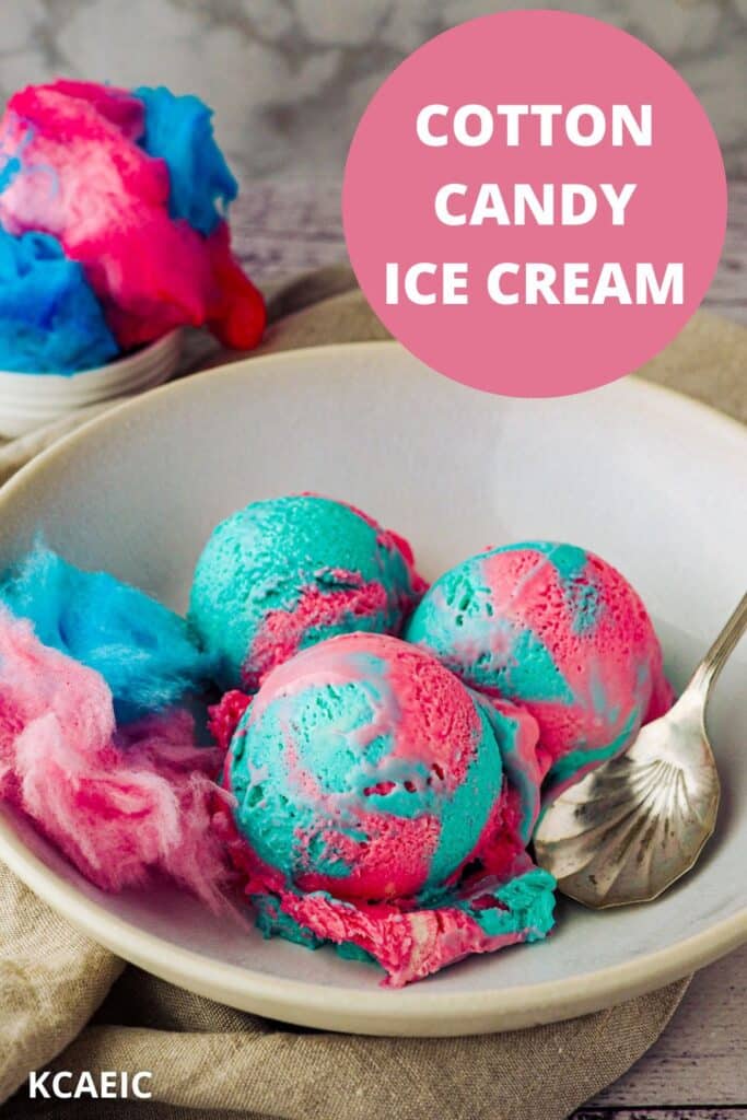 Scoops of cotton candy ice cream in a bowl with a spoon and pink and blue cotton candy.