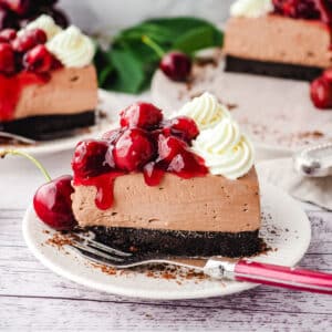 Slice of black forest cheesecake on a plate with a fork.