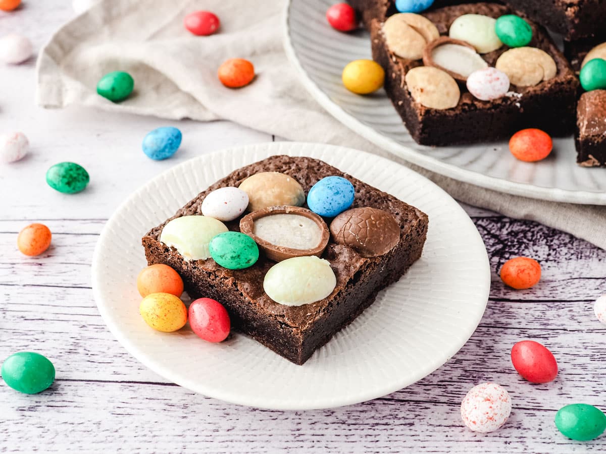 Easter brownie on a plate with extra Easter eggs, and rest of brownies on a plate in the background.