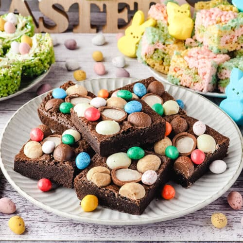 Close up shot of Easter brownies on a plate with Easter desserts in the background.