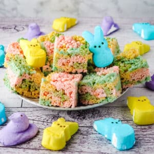 Peeps rice krispie treats on a plate with Peeps on the side.