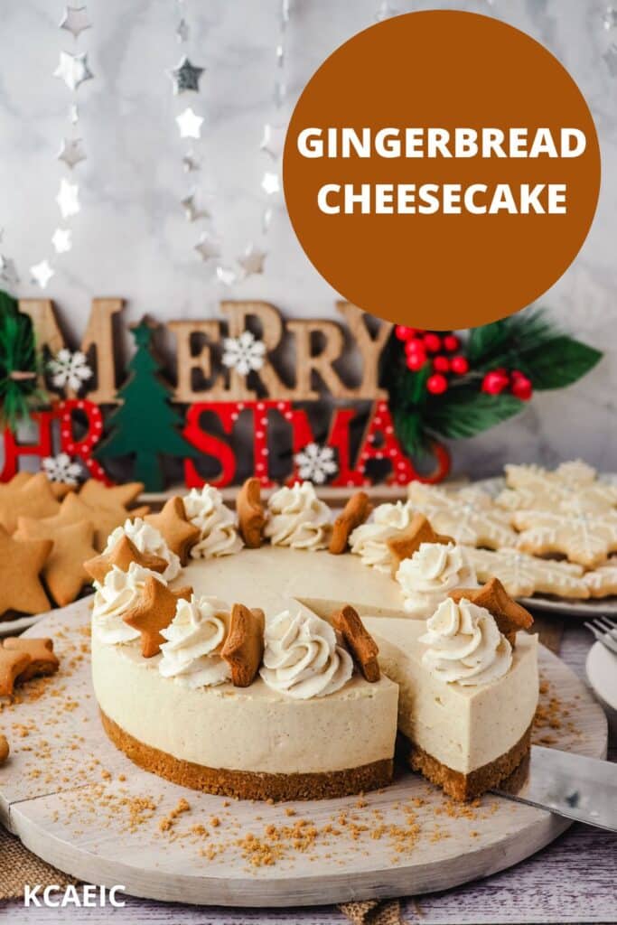 Slicing a piece of gingerbread cheesecake on a serving board, surrounded by Christmas desserts and decorations.