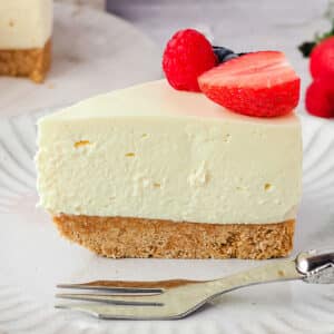 No bake cheesecake recipes, slice of base recipe, on a plate with a fork and fresh fruit.