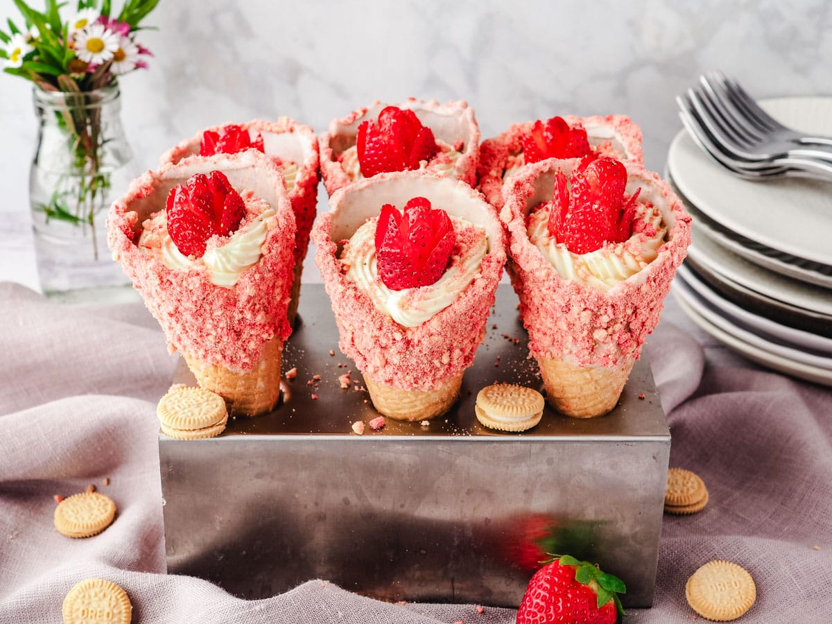 Serving strawberry cheesecake crunch cones in an ice cream cone holder.