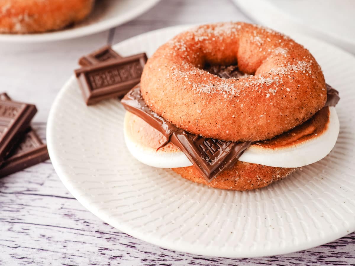 Smore Donuts 9 A smore donut on a plate with pieces of Hershey’s chocolate on the side.