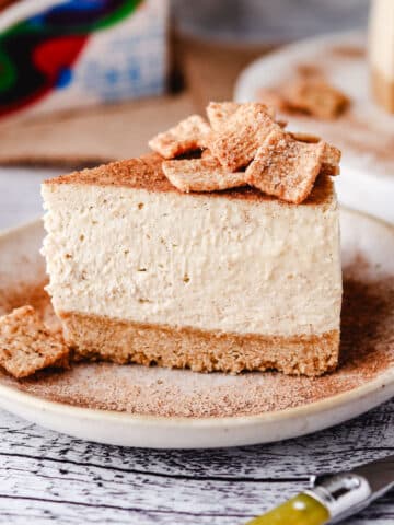 Close up shot of a slice of Cinnamon Toast Crunch cheesecake on a plate.