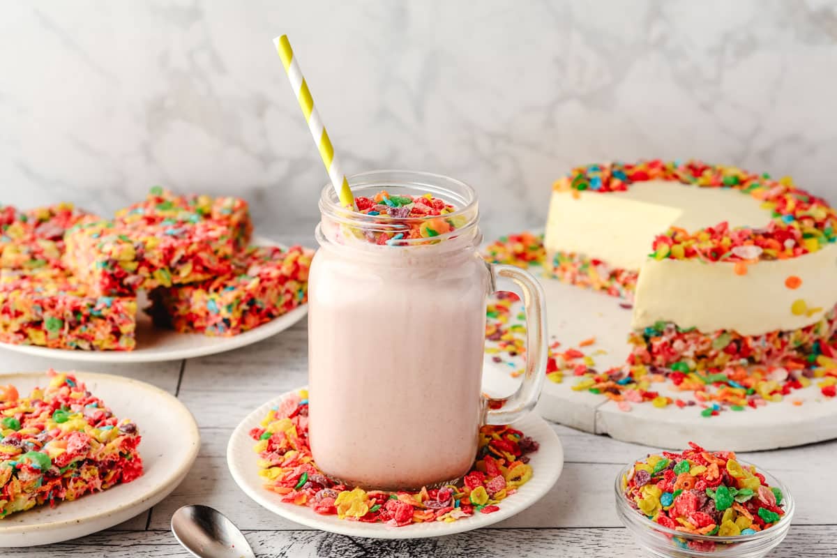 Fruity Pebbles Milkshake 6 Fruity Pebbles milkshake in a glass jar, decorated with Fruity Pebbles, with other Fruity Pebbles desserts in the background.