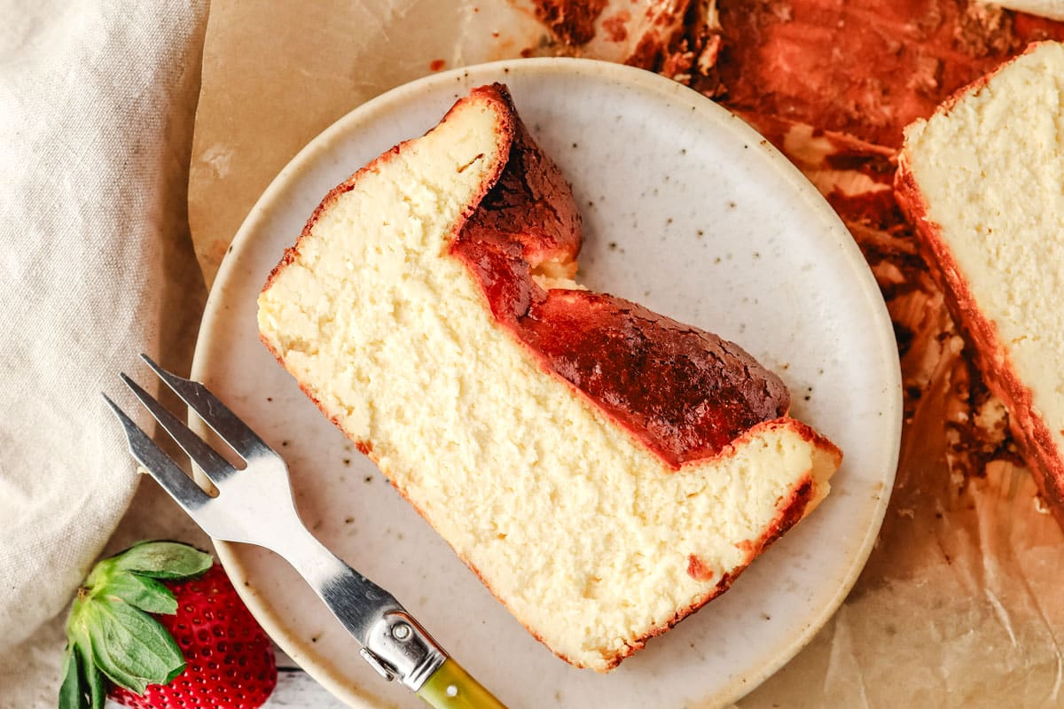 Top view of a slice of Basque cheesecake made in a loaf pan, with a fork on the side.