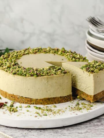 Pistachio Cheesecake 27 Close up of taking a slice out of a pistachio cheesecake on a serving board.