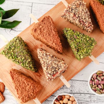 Cheesecake Sticks 19 Biscoff, pistachio and Nutella cheesecake sticks on a serving board.