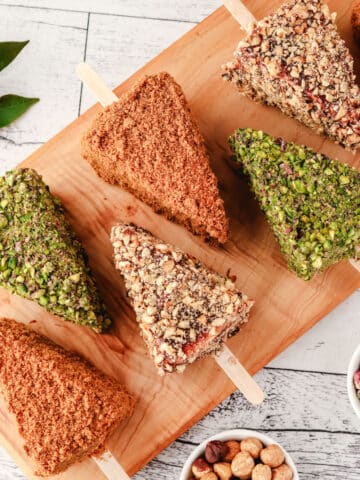 Cheesecake Sticks 26 Biscoff, pistachio and Nutella cheesecake sticks on a serving board.