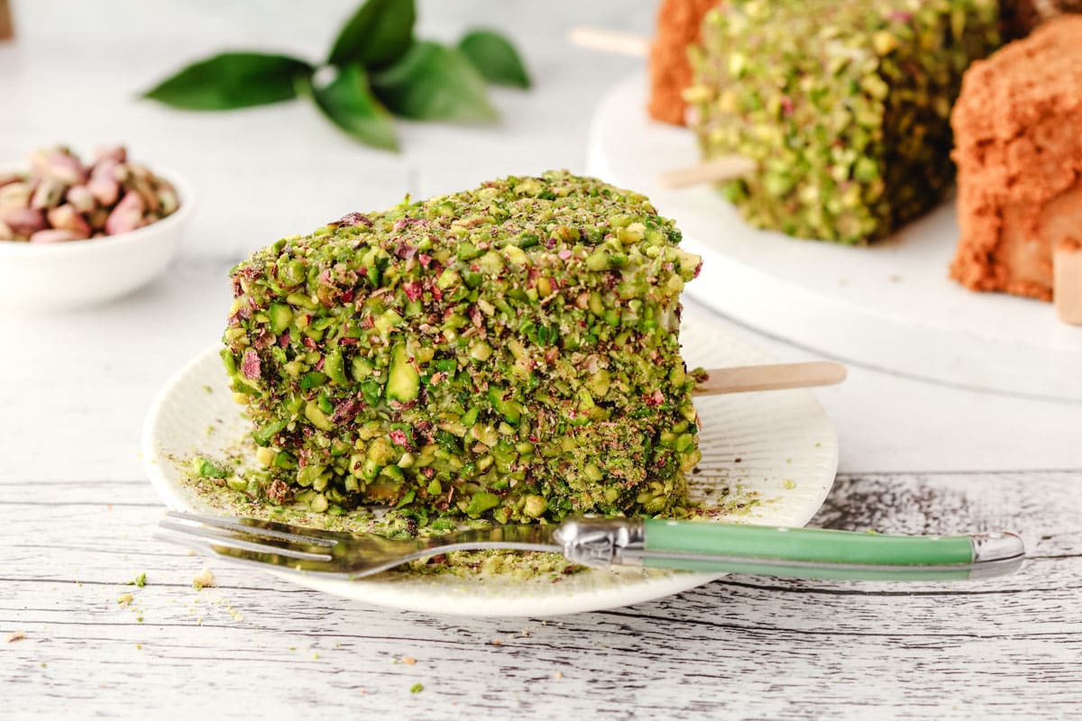 Cheesecake Sticks 16 Pistachio cheesecake stick on a plate with a fork.