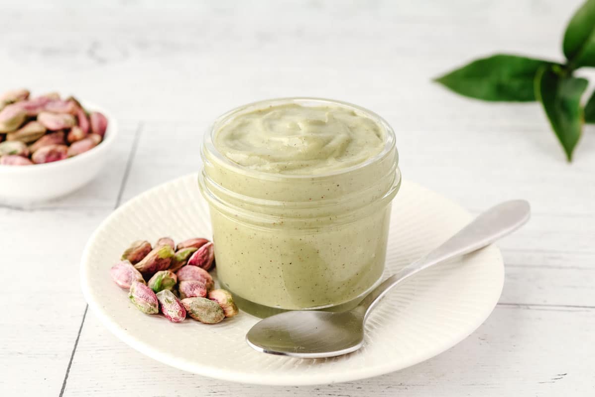 Spooning pistachio topping from a jar