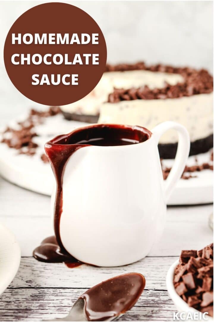 Homemade Chocolate Sauce 1 Jug of chocolate sauce with chocolate chip cheesecake in the background. Text overlay reads: Homemade Chocolate Sauce top left and KCAEIC bottom right.